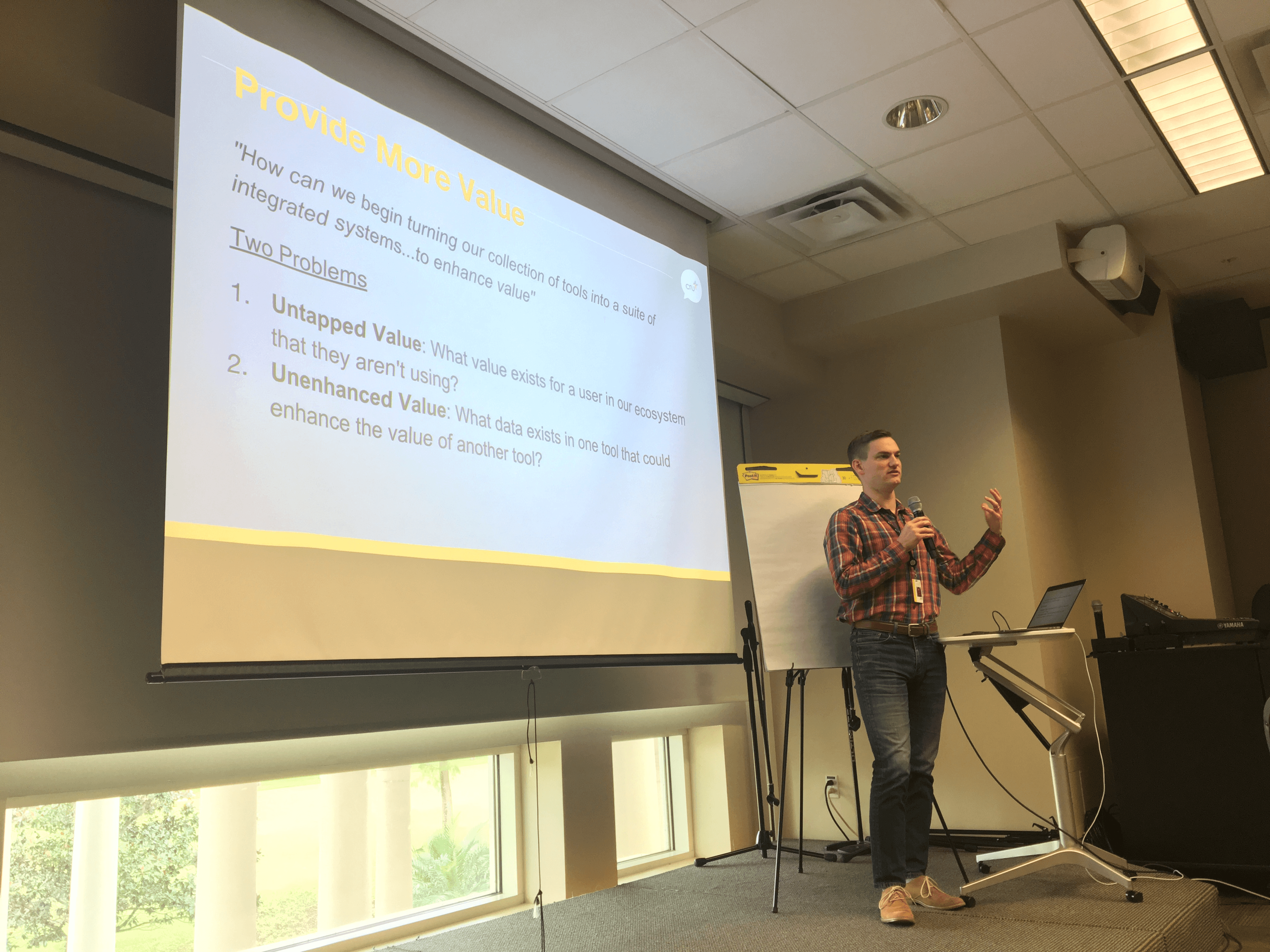 Nate on-stage, giving a presentation, microphone and gesturing hand aloft